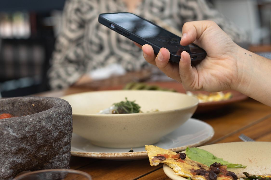 料理をスマートフォンで撮影する手元